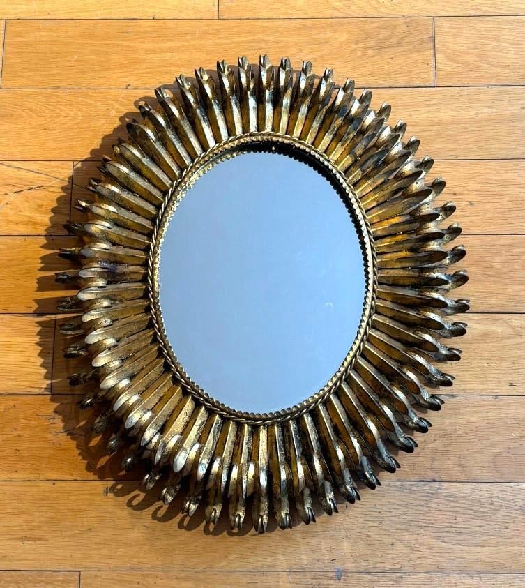 GILT METAL OVAL SUNBURST MIRROR IN THE STYLE OF JANSEN – ITALIAN HOLLYWOOD REGENCY STYLE: A continental gilt metal oval sunburst mirror with layered leaf-form rays Pick up Note: This lot located in Manhattan NYC, and must picked up in Manhattan. Estimated Approximate Dimensions: 23" T 