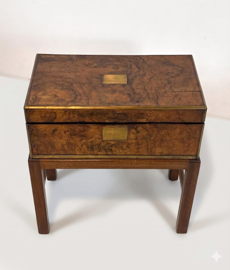 ANTIQUE VICTORIAN BRASS-BOUND WRITING SLOPE ON CUSTOM STAND: A 19th century English campaign-style figured walnut lap desk box with brass corner banding and a central brass presentation plaque, presented on a later-added square-leg base stand. Approximate Dimen