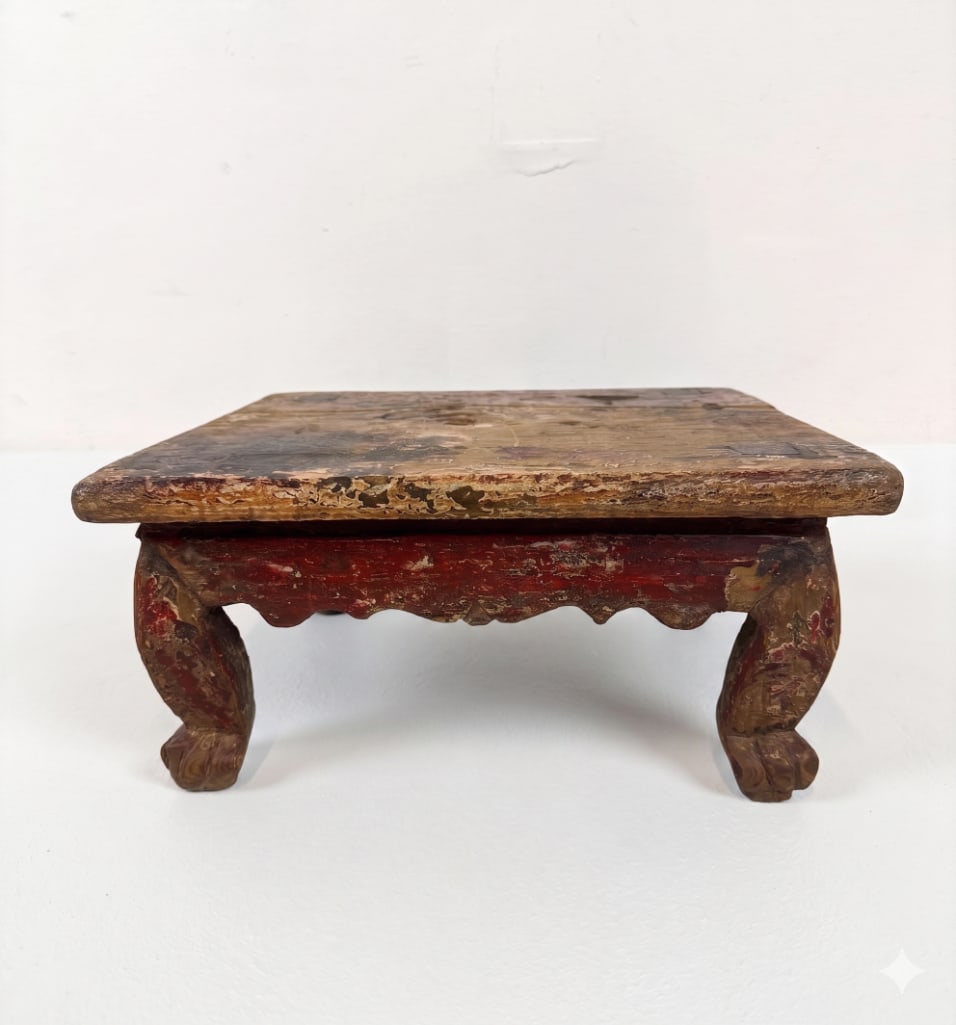 ANTIQUE CHINESE RED LACQUER LOW KANG STOOL TABLE: An antique Asian square meditation platform with weathered polychrome cinnabar red lacquer layers, a scalloped apron, and sturdy cabriole legs. Approximate Dimensions: 16.5” x 18” x 9&rdqu