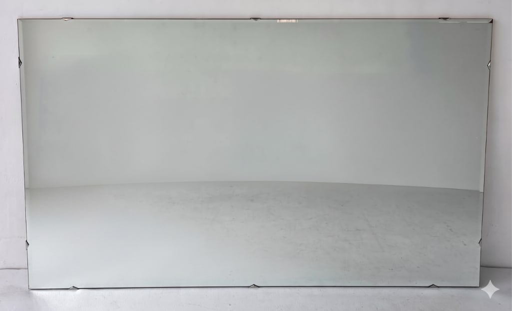 MID-CENTURY MODERN LARGE EMBELLISHED BEVELED WALL MIRROR: A Mid-Century Modern large horizontal wall mirror. The frameless plate glass features beveled perimeter edges punctuated by small decorative notched or diamond-cut edge detailing held by subtle integr