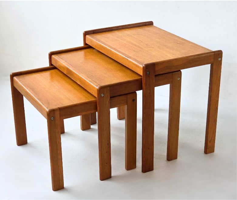SET OF THREE TEAK NESTING TABLES: Set of three Mid-Century Modern nesting tables crafted in rich teak wood. Approximate Dimensions: 20.25"h x 23.75"w x 16"d 17.5"h x 21.75"w x 16"d 15"h x 19.75"w x 16&#