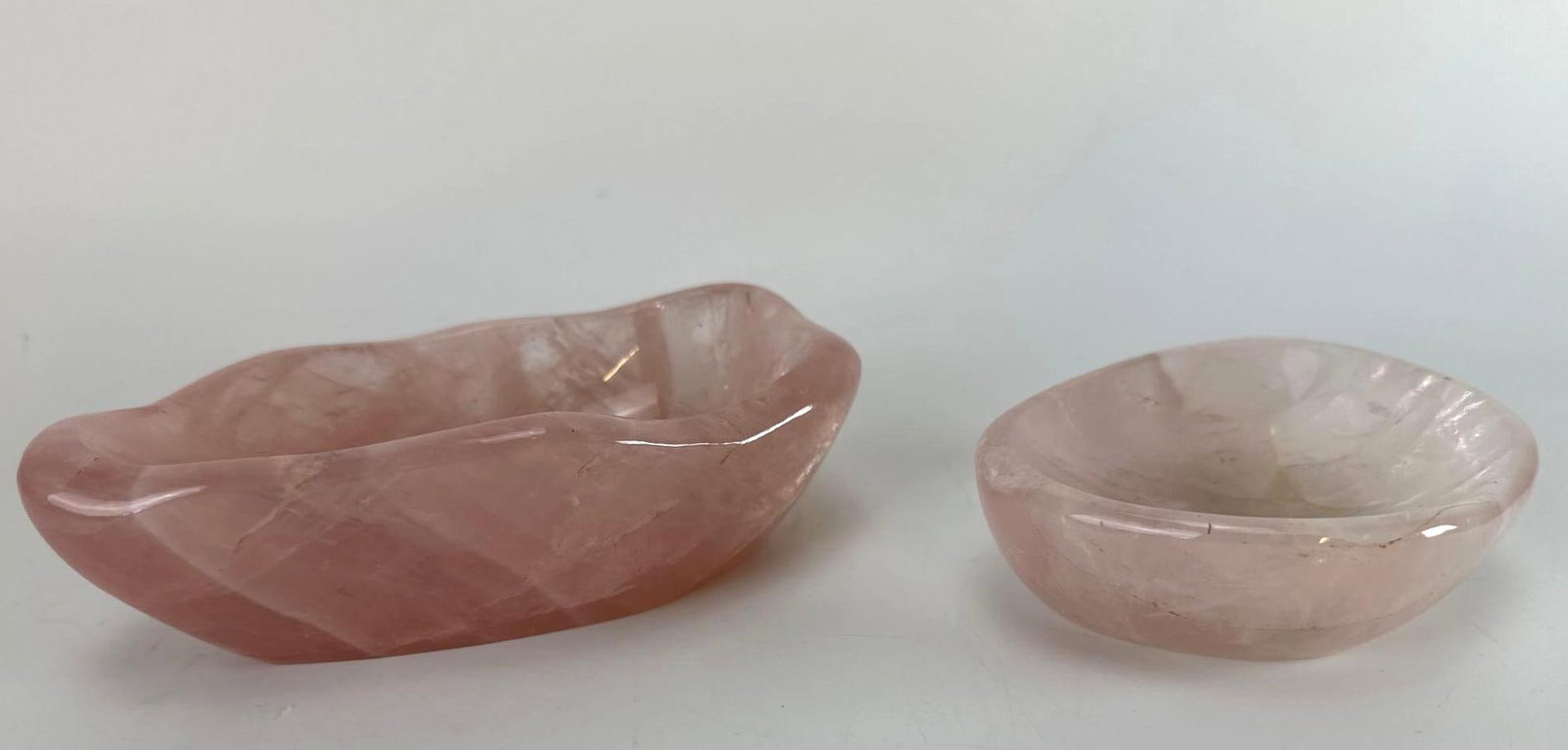 TWO CHINESE HAND-CARVED ROSE QUARTZ FREEFORM DISHES: A pair of Chinese hand-carved natural rose quartz semiprecious hardstone scholarly objects comprising an elongated freeform brush washer bowl and a companion shallow round dish with highly polished in