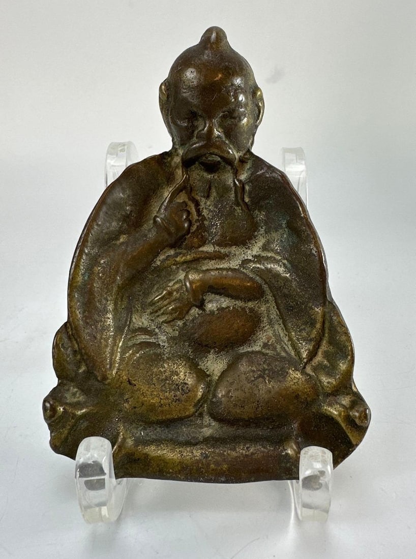 ANTIQUE CHINESE CAST BRONZE SEATED LUOHAN MONK ASHTRAY FIGURE: Patinated cast bronze sculptural dish depicting a seated ascetic figure with a recessed hollowed base. Approximate Dimensions: 6”x 4” Artist or Maker: Unknown Provenance: