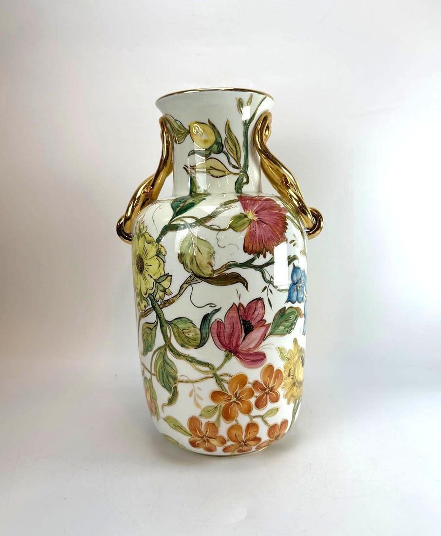 ITALIAN PORCELAIN HAND PAINTED FLORAL VASE SIGNED AND NUMBERED: A hand-painted Italian porcelain urn vase with vibrant multi-colored botanical flora, gilt gold accents, and dual twisted gold handles. Approximate Dimensions: 17"H x 11"Dia Artist or Maker: I