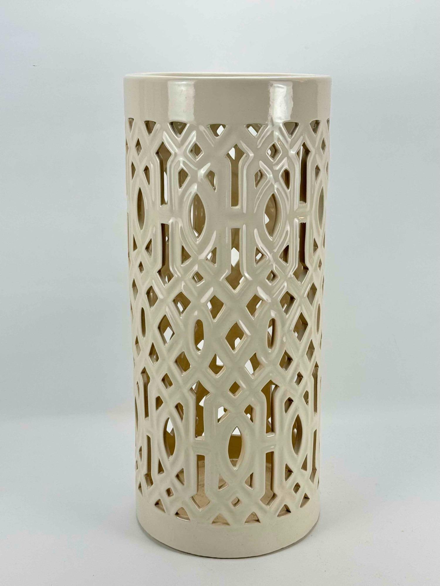 BD COLLECTION CERAMIC PATIO UMBRELLA HOLDER: Cream glazed ceramic cylindrical umbrella stand with a cut-out geometric lattice design Approximate Dimensions: 23.75” H X 10.25” Dia. Artist or Maker: B.D. Provenance: A