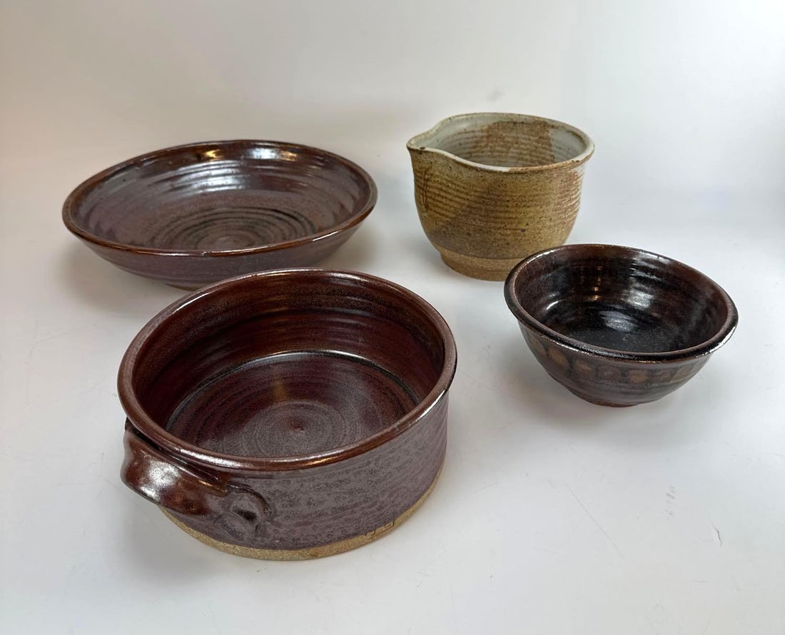 1970's SIGNED STUDIO POTTERY FOUR PIECE COLLECTION: A collection of four mid-century hand-thrown glazed stoneware ceramic vessels including a dual-handled casserole crock, shallow serving dish, mixing pitcher, and small bowl. Largest Approximate Dimens
