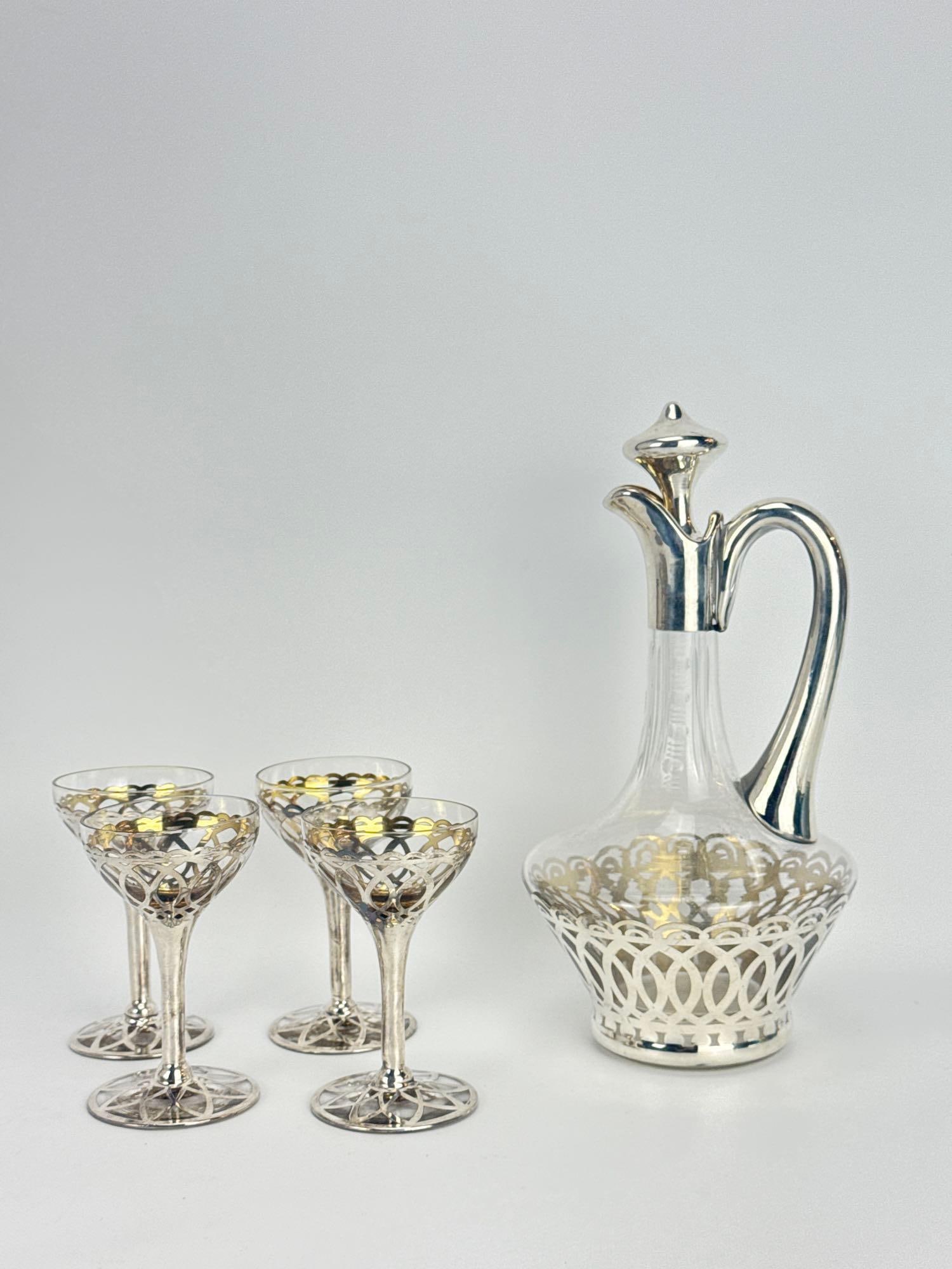 ART NOUVEAU STERLING SILVER OVERLAY GLASS LIQUEUR DECANTER AND CORDIAL SET: *Five-piece blown glass liqueur service comprising a handled claret decanter with matching stopper and four stemmed cordial glasses, with openwork floral trellis sterling silver overlay and faint inte