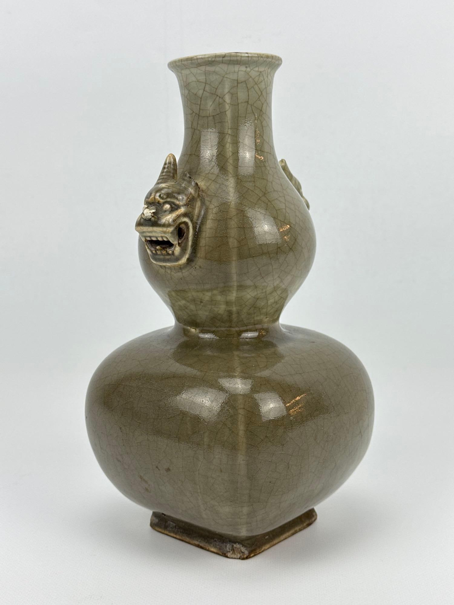 CHINESE GE-STYLE CELADON GLAZED DOUBLE GOURD VASE WITH YUNGCHENG MARK: *A Chinese square-form double gourd porcelain vase covered in a crackled olive-celadon Ge-type glaze, applied with molded stylized beast masks flanking the upper bulb, bearing a six-character Yongzhen