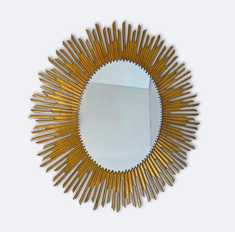 LARGE VINTAGE REGENCY STYLE FAUX WOOD OVAL SUNBURST WALL MIRROR: Large hanging plate glass mirror bordered by a molded composite radiant burst frame finished in an antiqued gold tone. Approximate Dimensions: 43.5"h x 39.5"w Artist or Maker: Unknown