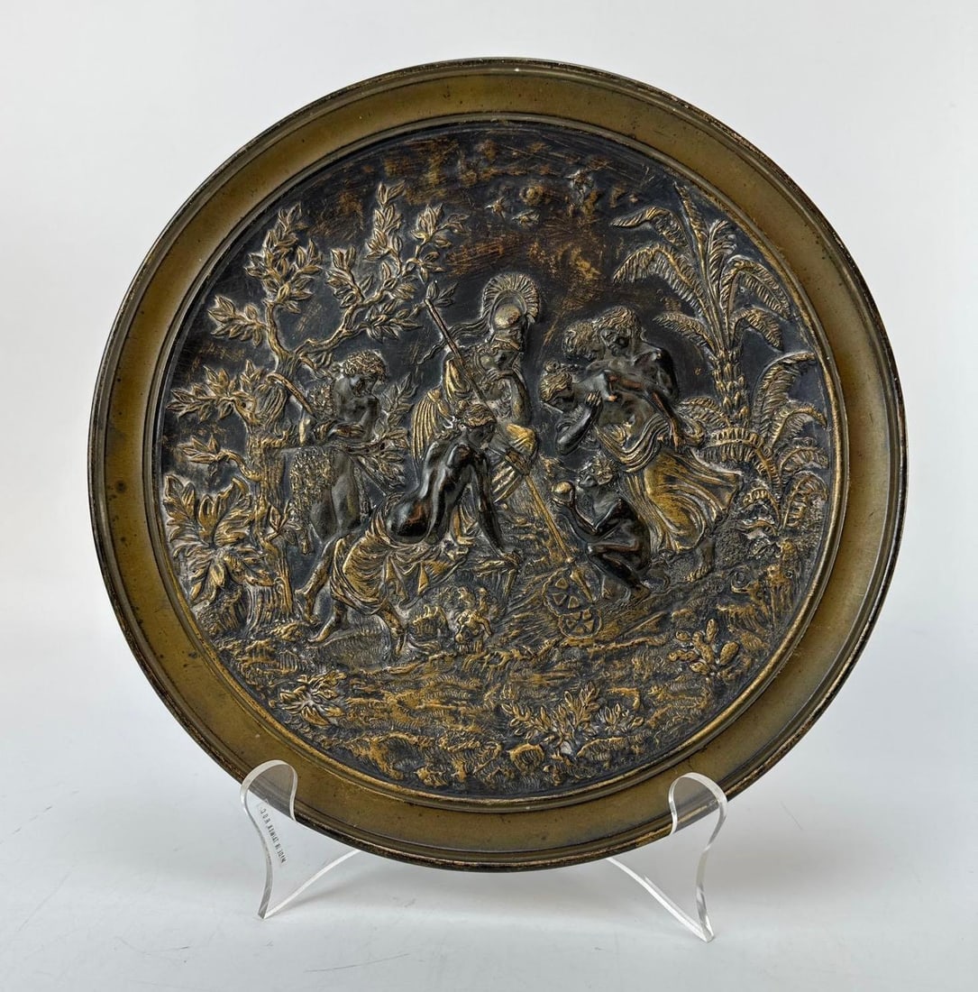 NEO CLASSICAL MANNER CIRCULAR GILT PORCELAIN HIGH RELIEF CHARGER STAMPED JM: *19th-century Neoclassical style circular patinated metal wall charger with a finely detailed high-relief repoussé mythological scene, mounted to a black lacquered wood backing stamped JM 5064. Appro