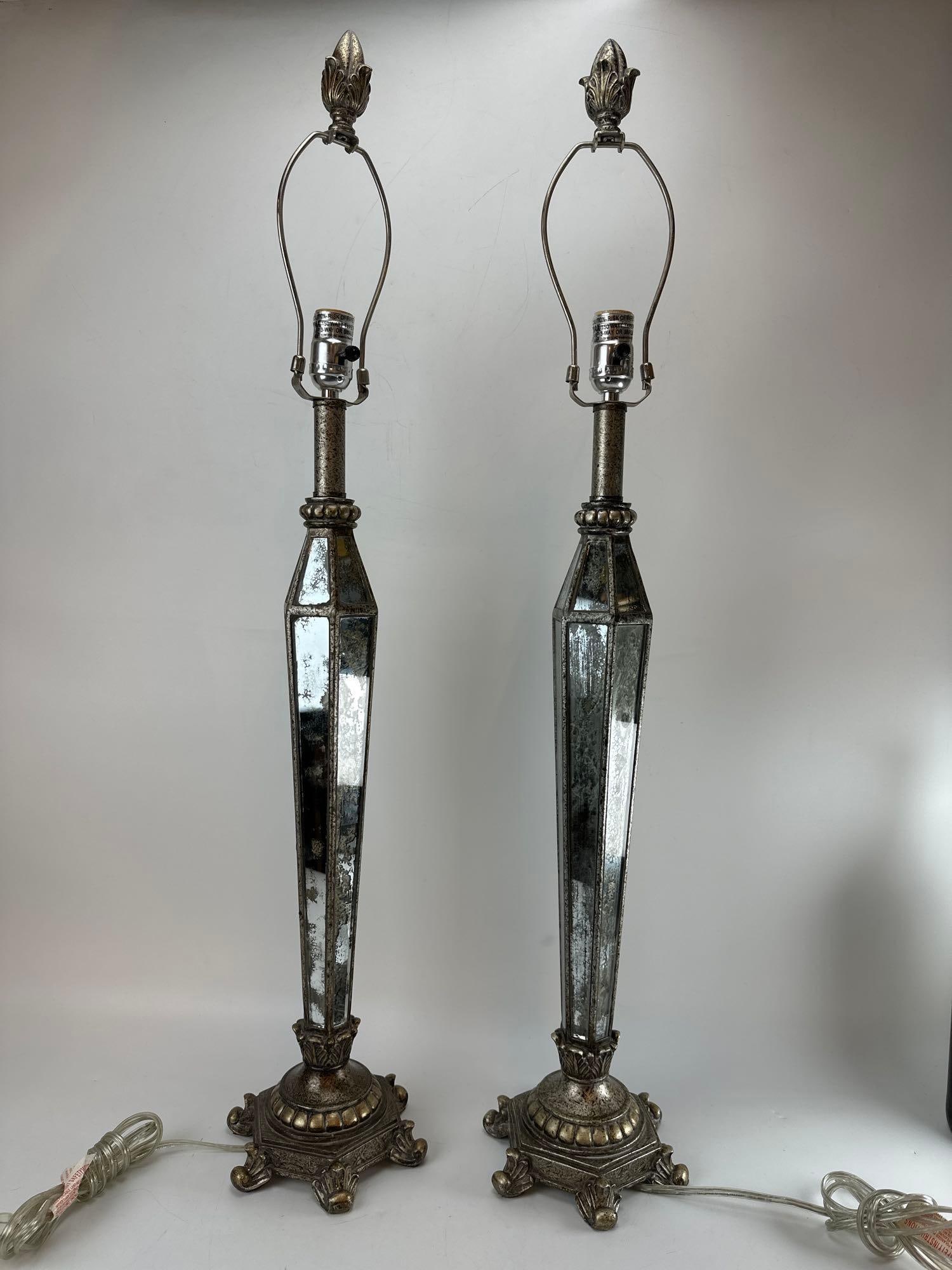 PAIR OF HOLLYWOOD REGENCY ANTIQUED MIRRORED OBELISK TABLE LAMPS: *Pair of Hollywood Regency style table lamps featuring elongated, faceted obelisk-form bodies inset with heavily distressed mercury-style antique mirrored glass panels, mounted on ornate cast metal ba