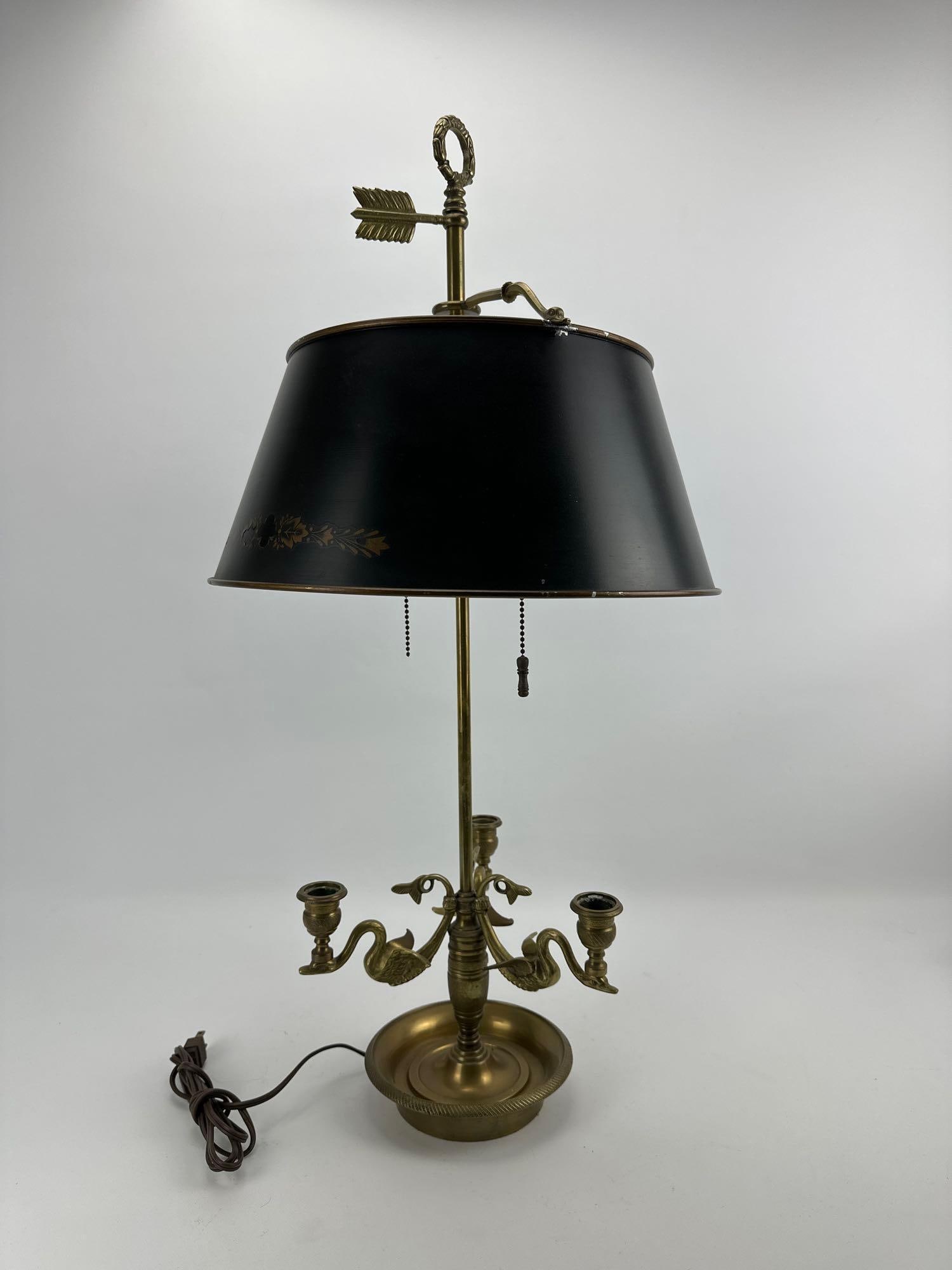 VINTAGE FRENCH EMPIRE STYLE BRASS SWAN BOUILLOTTE LAMP WITH TÔLE SHADE: Mid-20th-century classical revival three-light brass candlestick desk lamp topped by an adjustable black painted metal shade and an arrow finial. Approximate Dimensions: 14”diameter x 29”t