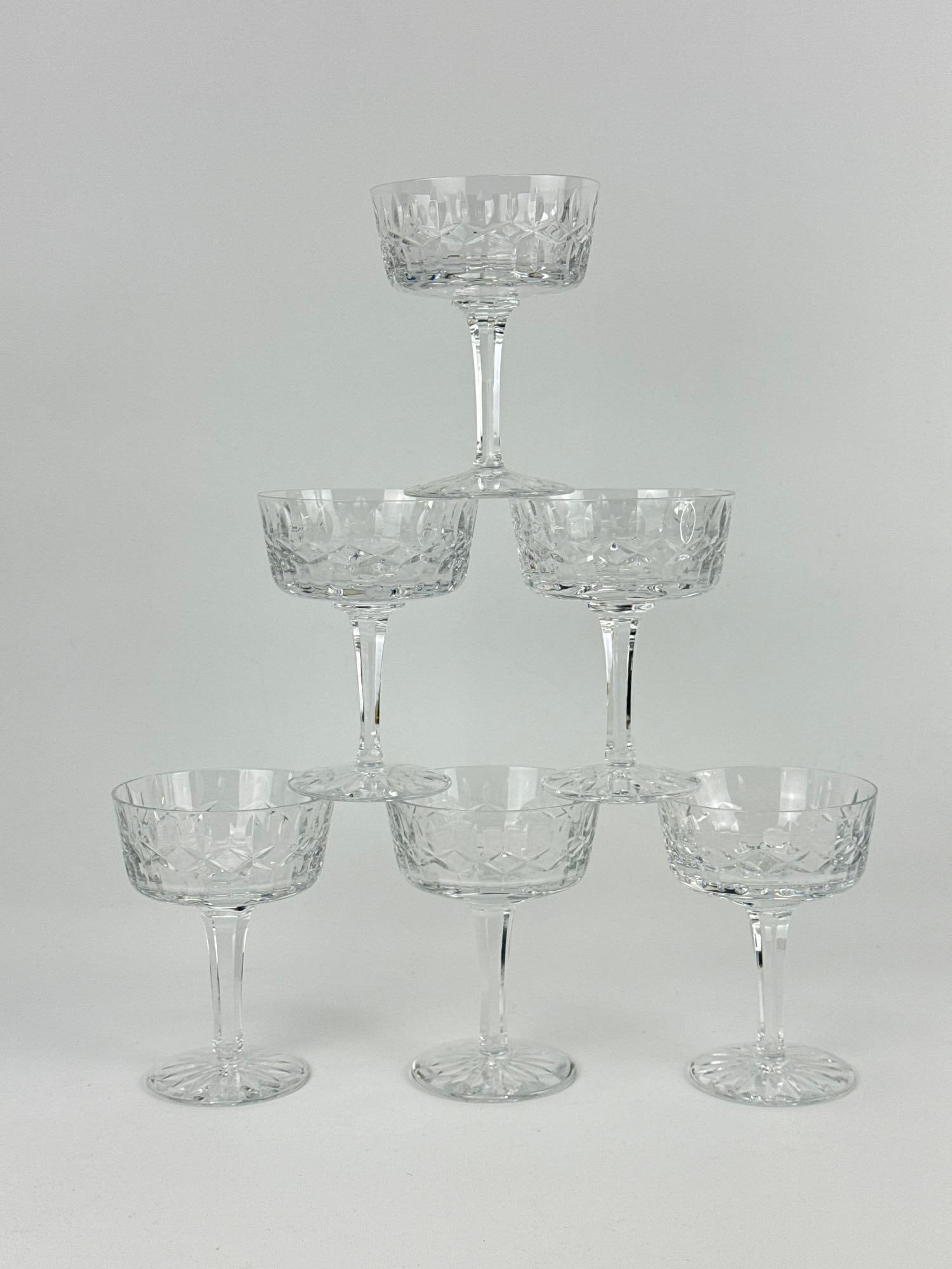 VINTAGE WATERFORD CRYSTAL COUPE SHERBET OR CHAMPAGNE GLASSES SET OF SIX: Collection of six fine Irish cut glass vessels with diamond and wedge cross-cuts on faceted stems. Approximate Dimensions: 5”h x 3.75”dia x 2.75”dia at base Artist or Maker: Waterfor