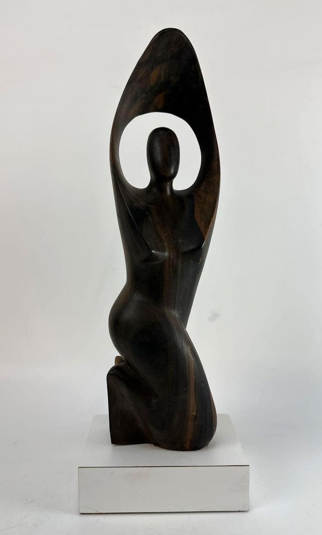 MID-CENTURY MODERN ABSTRACT CARVED WOODEN KNEELING FEMALE FIGURE SCULPTURE: Vintage hand-carved stylized wooden statuette of an elongated kneeling woman with raised arms on a square laminate base. Approximate Dimensions: 6”x4”x15” Artist or Maker: Unknown</