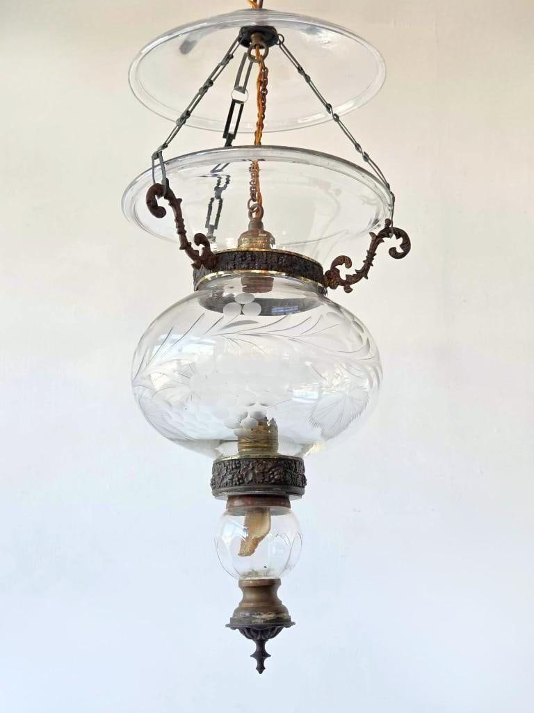 VINTAGE AMERICAN BRASS AND ETCHED GLASS BELL JAR FOYER LANTERN: Suspended glass bell jar hall lantern etched with subtle grape motifs and supported by an open brass collar band with an overhead smoke bell canopy. Approximate Dimensions: 26" H X 10" Dia. Ar