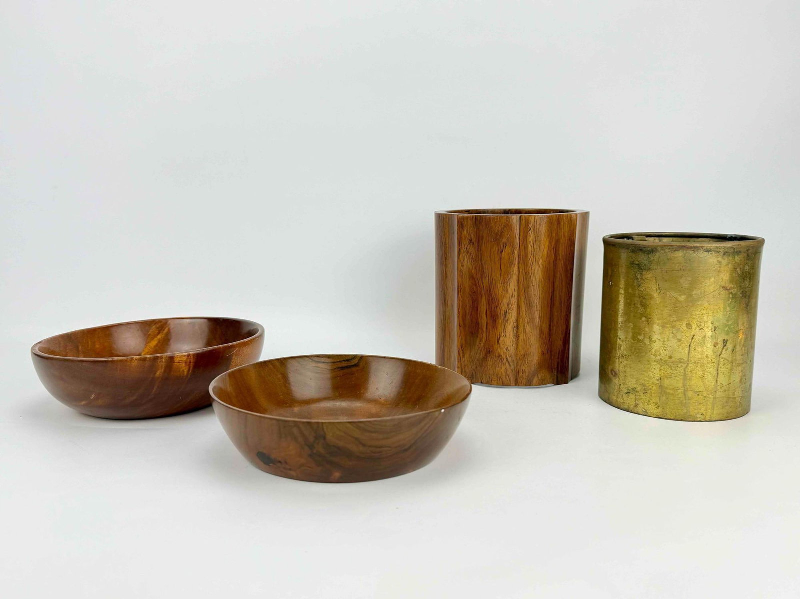 FOUR PIECE LOT OF SIGNED HAWAIIAN D. NELSON MILO WOOD BOWLS AND CONTAINERS: *Four-piece tabletop collection containing two hand-turned milo wood calabash bowls, a scalloped columnar wooden vessel with a patinated brass-clad liner. Approximate Dimensions: Largest: 6” x 5