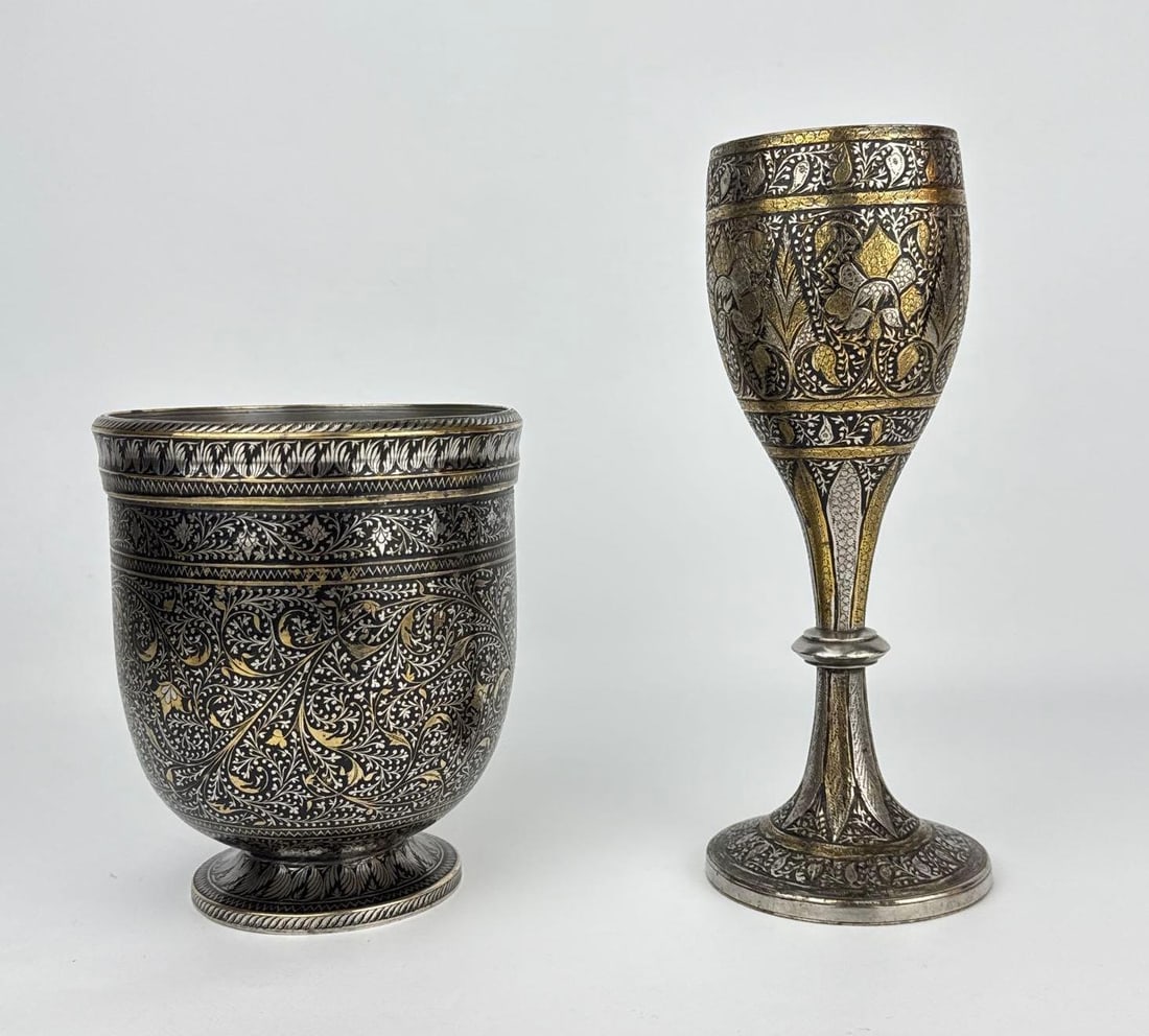 GROUP OF 2 ANTIQUE PERSIAN / INDO-ISLAMIC BIDRIWARE STYLE CHALICE & CUP VASES-SILVER: *An estate lot of two finely decorated antique metalware vessels showcasing intricate, dense foliate hand-engraving with striking niello-style blackened ground accents and select gilt enhancements. Ap