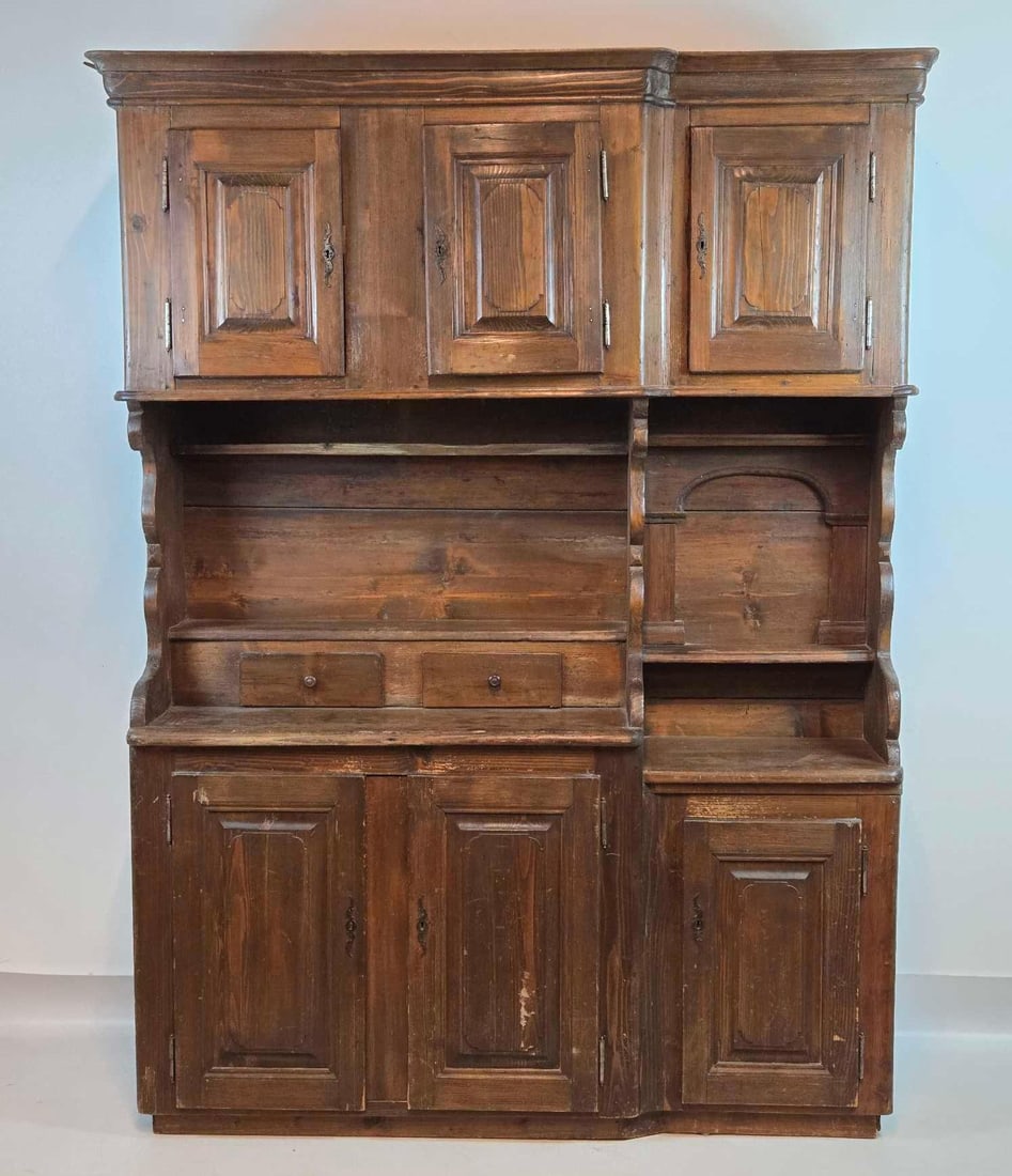 ANTIQUE 18TH CENTURY SWISS PINE AND FRUITWOOD STEP-BACK CUPBOARD: *Hand-carved large-scale European continental storage cabinet with three upper raised-panel doors, open middle shelving with integrated drawers, and a three-door lower commode base. Approximate Dimens