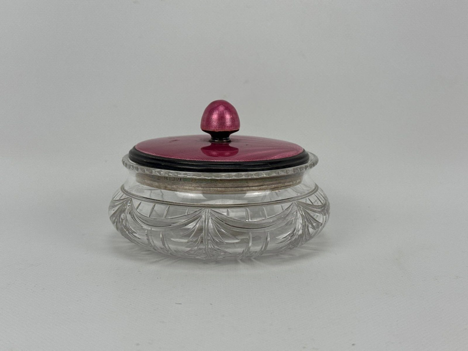 ANTIQUE GUILLOCHE ENAMEL AND STERLING SILVER MOUNTED CUT GLASS DRESSER JAR: Squat circular cut crystal vanity powder bowl with a purple guilloche enamel and silver lidded cover Approximate Dimensions: 2.75” H X 4.25” Dia. Artist or Maker: Unknown