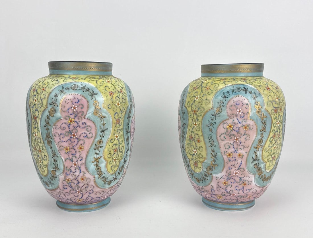 PAIR OF ANTIQUE BOHEMIAN ENAMELED OPALINE GLASS URN VASES: A pair of 19th-century tricolor cased opaline glass mantle urns decorated with heavily textured hand-painted polychrome floral enamel medallions and fine gilded borders. Approximate Dimensions: 10.5&r