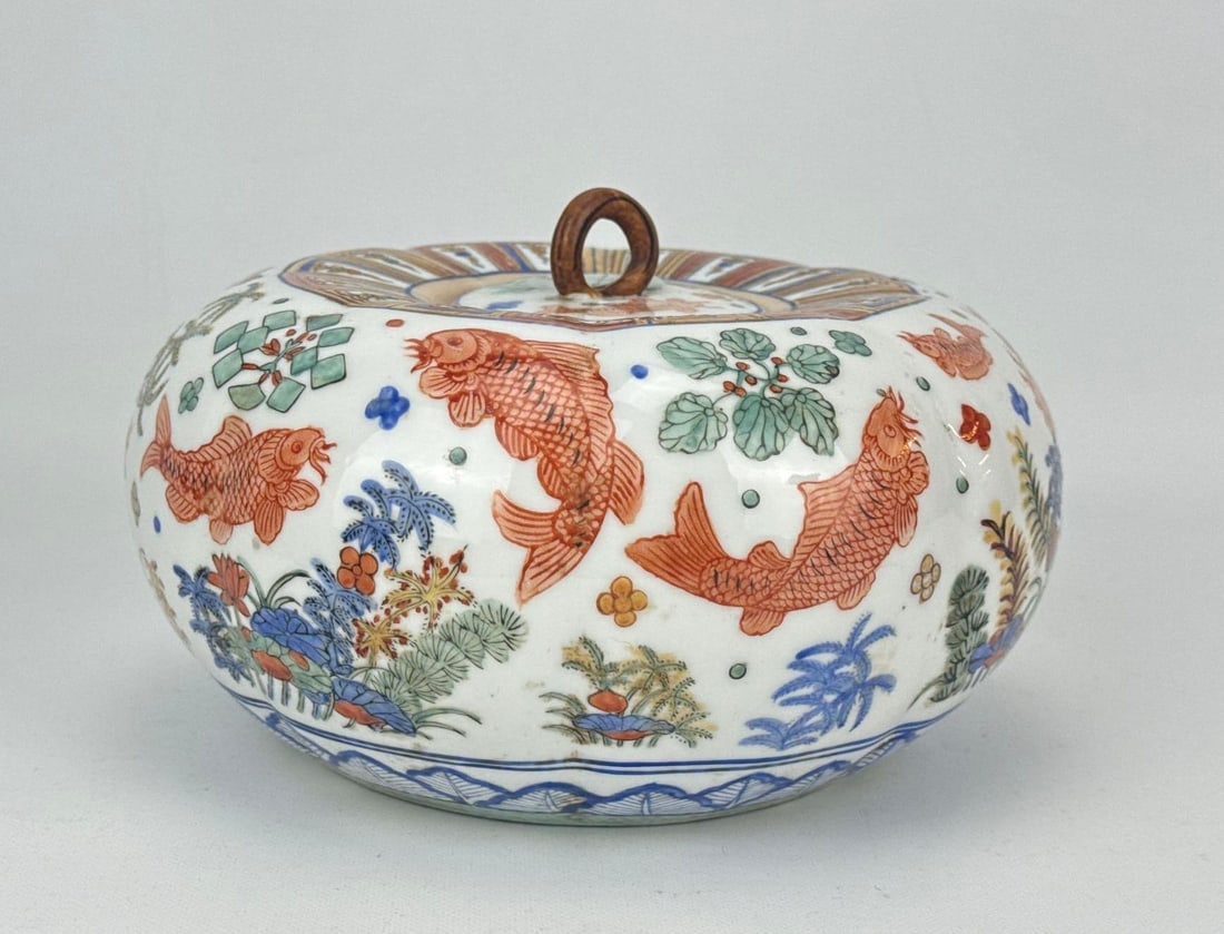 CHINESE WUCAI PORCELAIN LOBED COVERED FISH JAR: A Chinese polychrome porcelain lobed jar with matching lid decorated in the Ming Jiajing style. Approximate Dimensions: 5.5” H X 9” Dia. Artist or Maker: Unknown Provenance: From