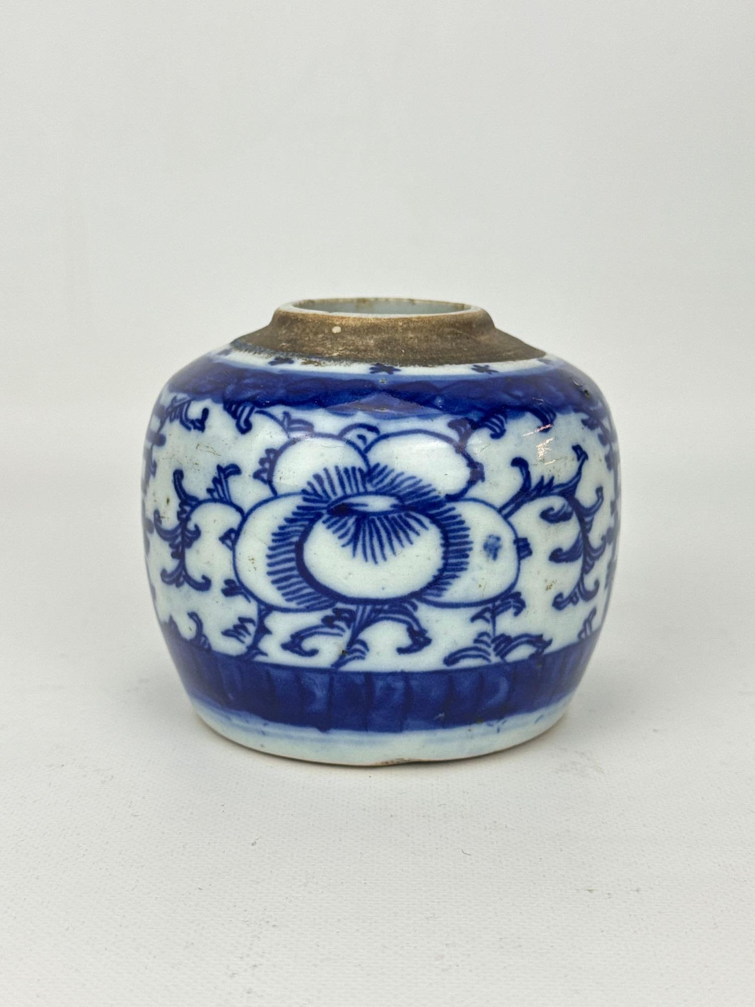 ANTIQUE CHINESE BLUE AND WHITE PORCELAIN MINI GINGER JAR: A small 19th-century Chinese blue and white porcelain ovoid ginger jar decorated in underglaze cobalt blue with large stylized peony blossoms and scrolling foliage above a stylized leaf border, the un