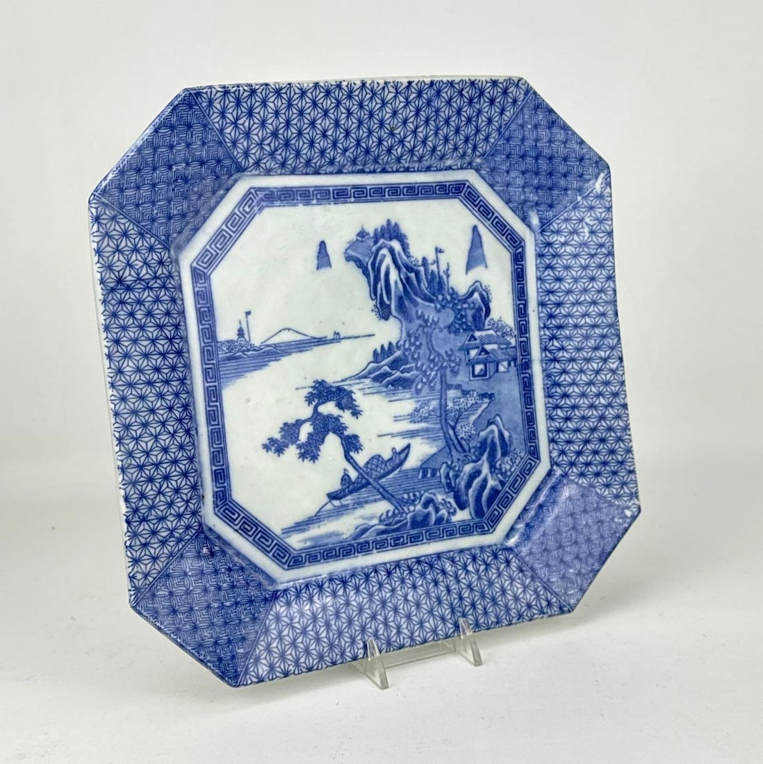 ANTIQUE JAPANESE ARITA IMARI BLUE AND WHITE PORCELAIN OCTAGONAL LANDSCAPE PLATE: Antique Japanese underglaze blue and white octagonal porcelain plate hand-painted with a mountainous river landscape. Approximate Dimensions: 1.25” H X 10” X 10” Artist or Maker: Unk