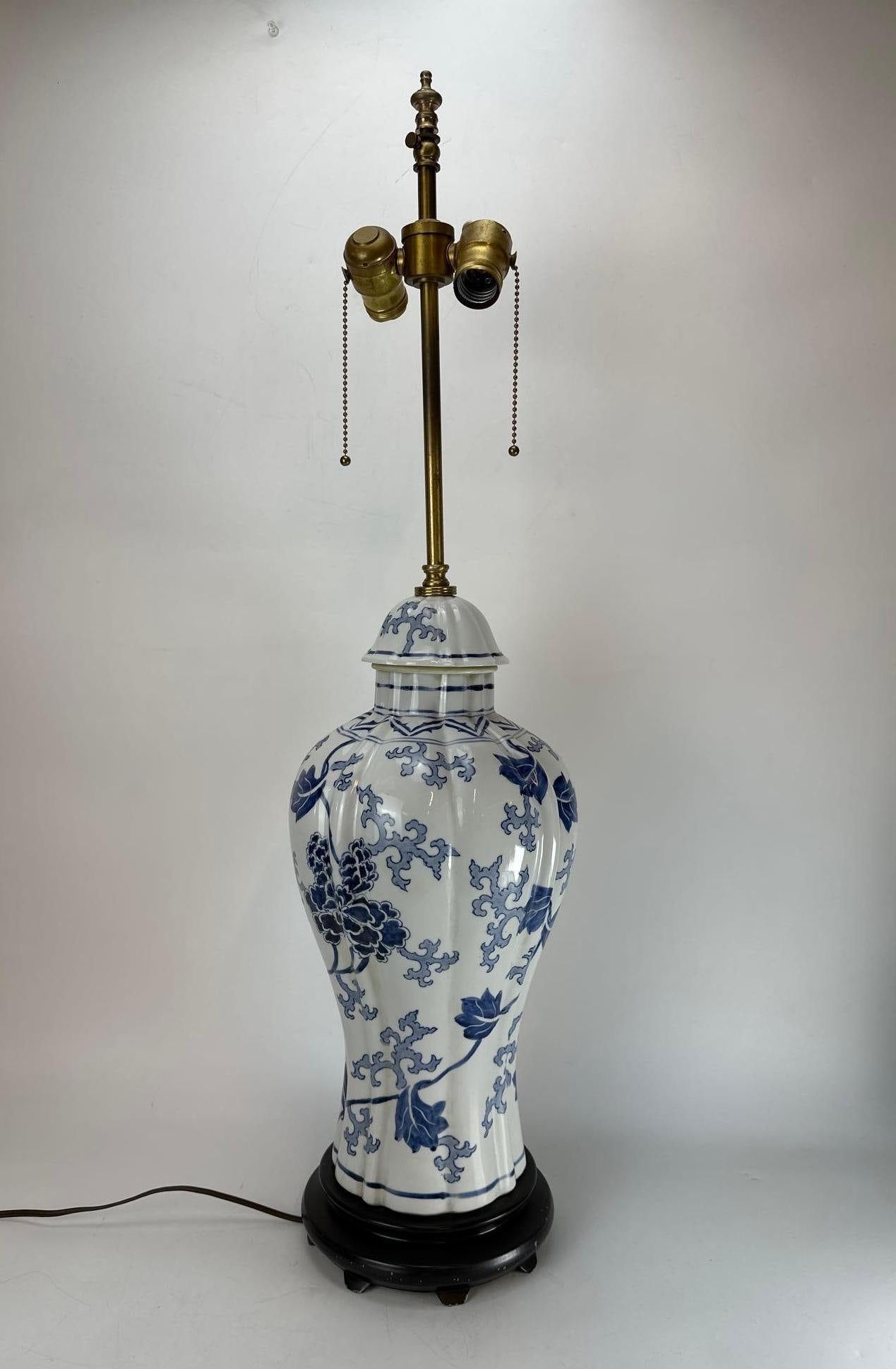 LARGE VINTAGE CHINESE BLUE AND WHITE PORCELAIN LOBED BALUSTER VASE LAMP: Large vintage Chinese export style underglaze blue and white porcelain lobed baluster table lamp painted with a continuous pattern of scrolling lotus blossoms and stylized foliage, mounted with a matc