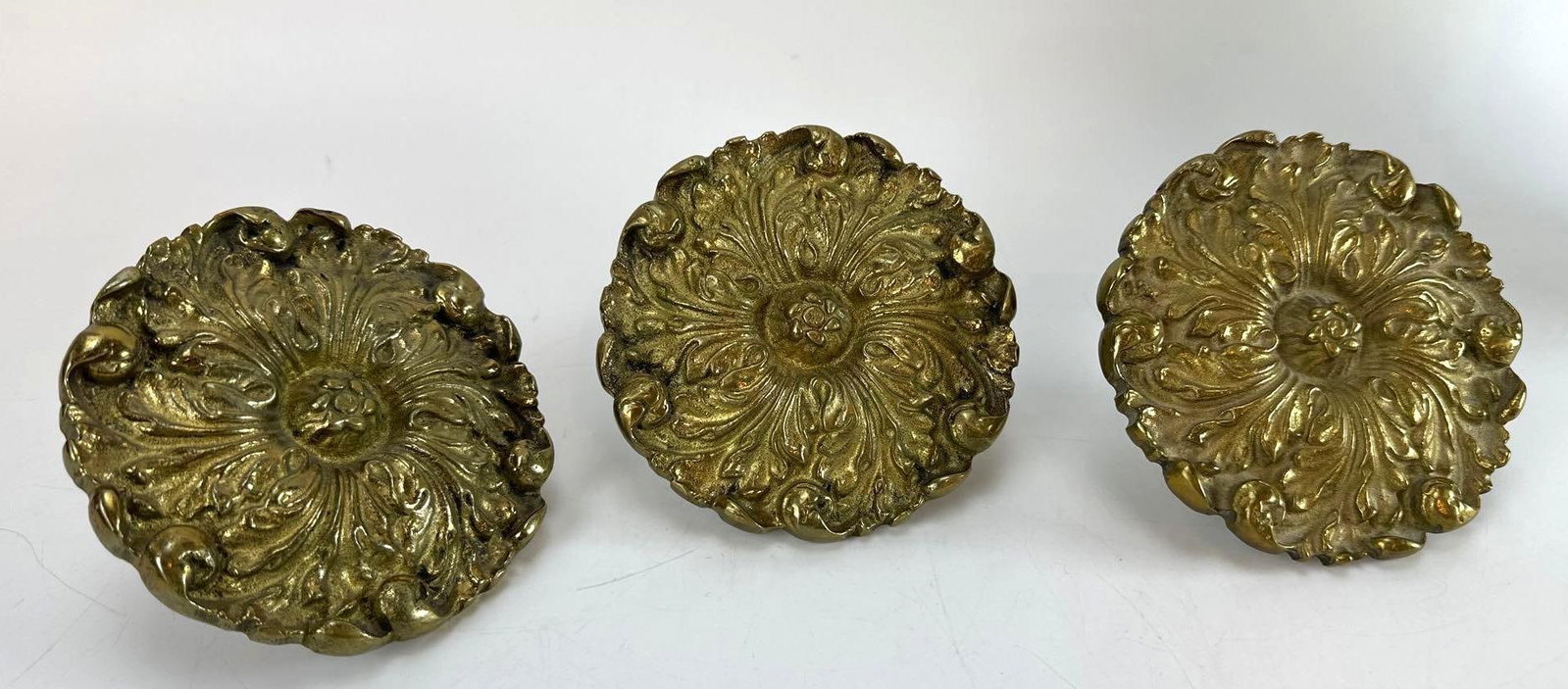SET OF 3 VINTAGE BRASS ROSETTE CURTAIN TIEBACKS: Set of three vintage brass drapery tieback medallions featuring a bold, classical layered rosette form with crisp petal detailing and integrated mounting screws Approximate Dimensions: 5”diamete