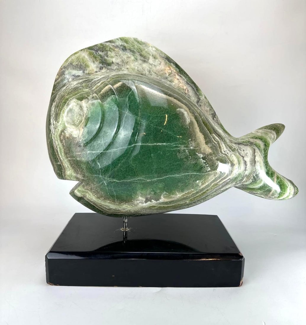 LARGE MID-CENTURY MODERN STYLIZED GREEN JADE ONYX MARBLE FISH SCULPTURE: Large mid-century modern stylized fish sculpture carved from heavily veined green jade-colored onyx marble mounted with a metal rod on a black rectangular plinth base. Note loss to tip of rear fin in