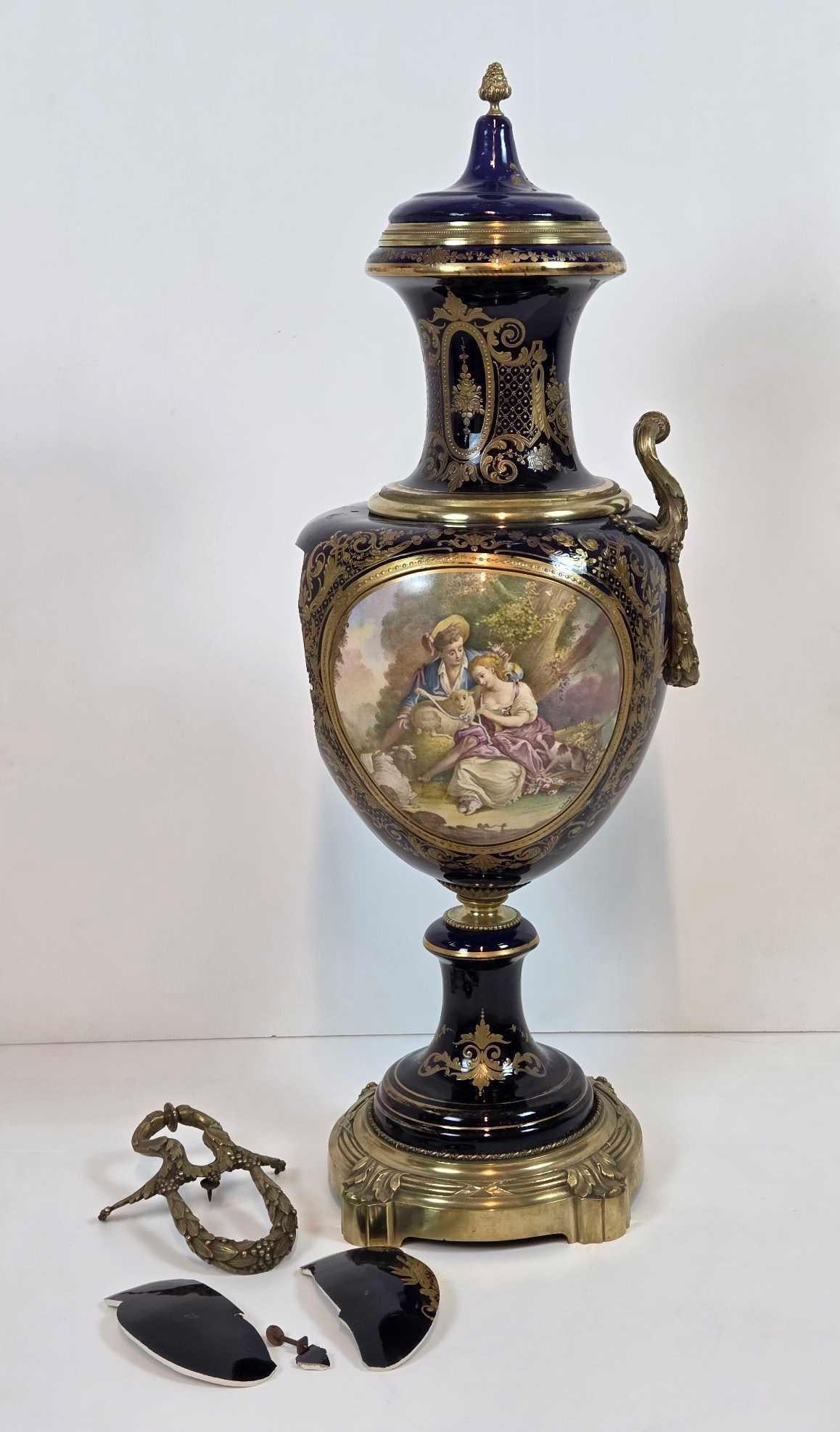 SEVRES COBALT AND GILT BRONZE MOUNTED COVERED URN AS FOUND: *Nineteenth century French Sevres style cobalt blue porcelain and ormolu mounted lidded urn showing a hand painted romantic Courting scene reserve signed by the artist, accompanied by a detached bronz