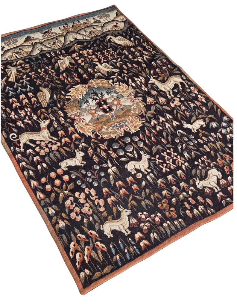 VINTAGE FRENCH JP PARIS MILLEFLEURS JACQUARD WALL TAPESTRY: Vertical woven textile wall hanging depicting a medieval millefleurs style floral field filled with animals, birds, and a central coat of arms medallion beneath a top border showing a village landscap