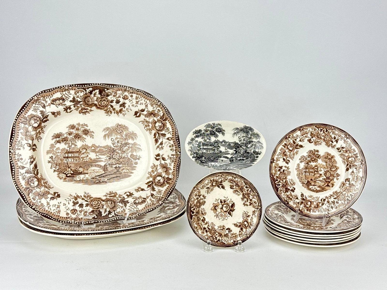 CLARICE CLIFF ROYAL STAFFORDSHIRE TONQUIN BROWN TRANSFERWARE DINNERWARE LOT: An assembly of vintage English porcelain tableware in the brown and white Tonquin oriental landscape pattern comprising platters, plates, and small dishes Approximate Dimensions: 1.25” H X 11.5&