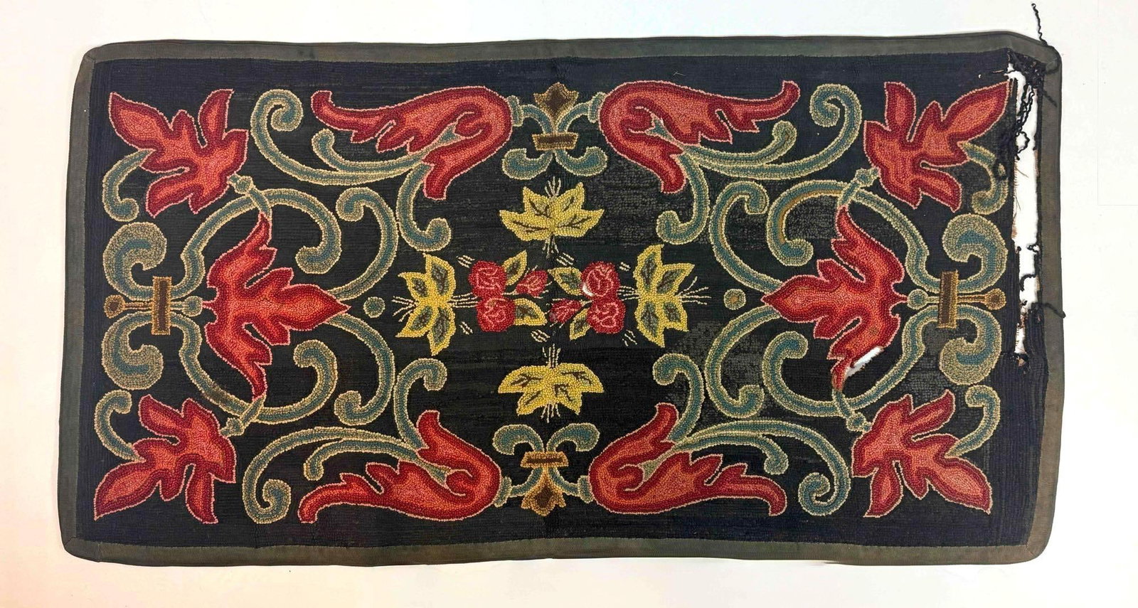 EARLY AMERICAN ANTIQUE HAND HOOKED WOOL HEARTH RUG YARN SEWN FLORAL SCROLL RUNNER: Early American antique hand-hooked wool yarn hearth rug runner or mat decorated with vibrant red and orange scrolling autumn leaves and floral motifs over a dark blue ground. Note loss in photos Appro