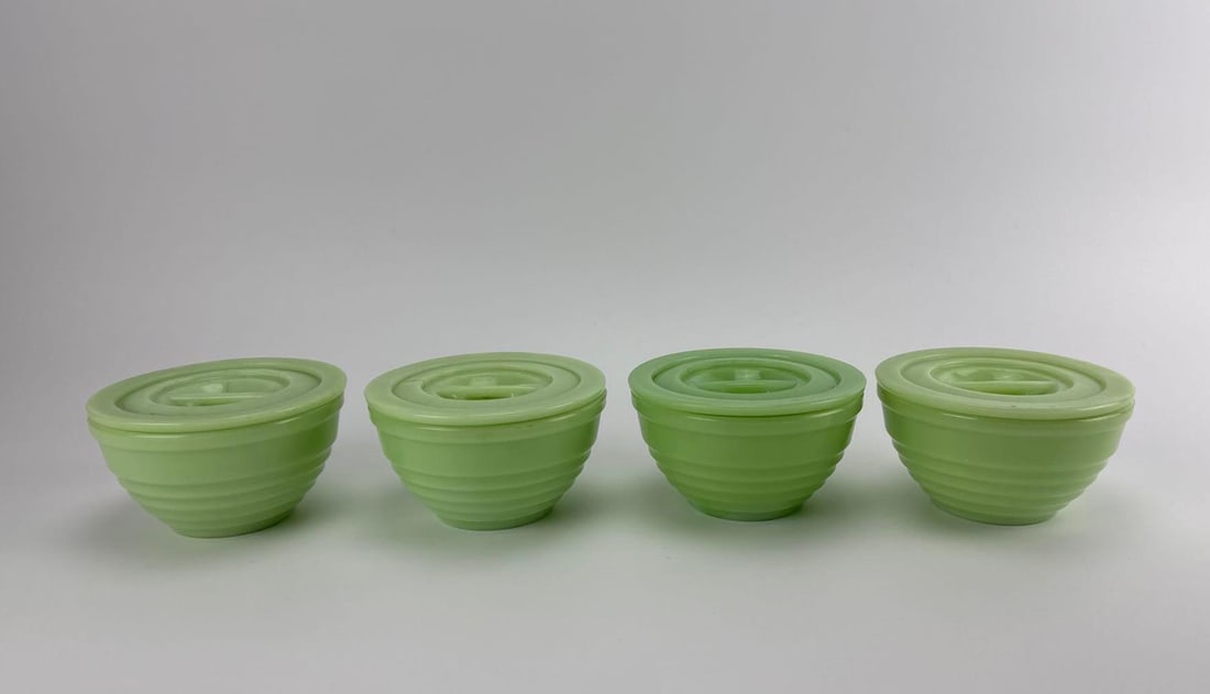 FOUR VINTAGE JEANNETTE GLASS CO. JADEITE BEEHIVE ROUND REFRIGERATOR DISHES WITH LIDS: Four-piece antique 1930s opaque green uranium jadeite glass round leftovers refrigerator storage set featuring horizontal beehive ribbing and matching flat tab-handled lids. Approximate Dimensions: 2.