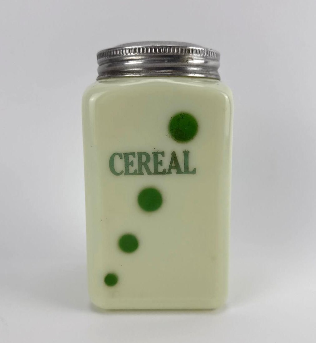RARE VINTAGE MCKEE GLASS CO. CUSTARD GLASS GREEN POLKA DOT CEREAL CANISTER WITH METAL LID: Antique 1930s yellow custard uranium glass square food canister with fired-on green polka dots, green typography, and original metal screw lid. Approximate Dimensions: 7" H x 3.5" W x 3.5" D Artist