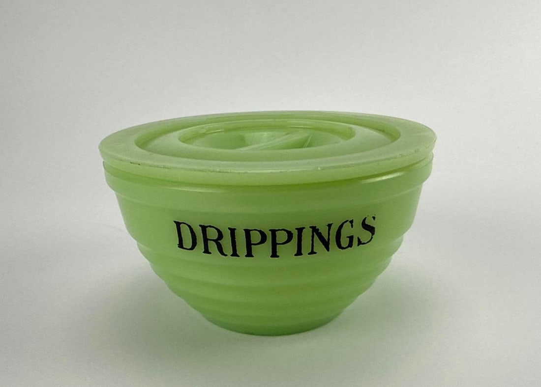 VINTAGE JEANNETTE GLASS CO. JADEITE BEEHIVE COVERED DRIPPINGS BOWL WITH LID: Antique 1930s opaque green uranium jadeite glass round drippings grease container with a matching ribbed flat-tab-handled lid. Approximate Dimensions: 2.75" h x 4.75" dia Artist or Maker: