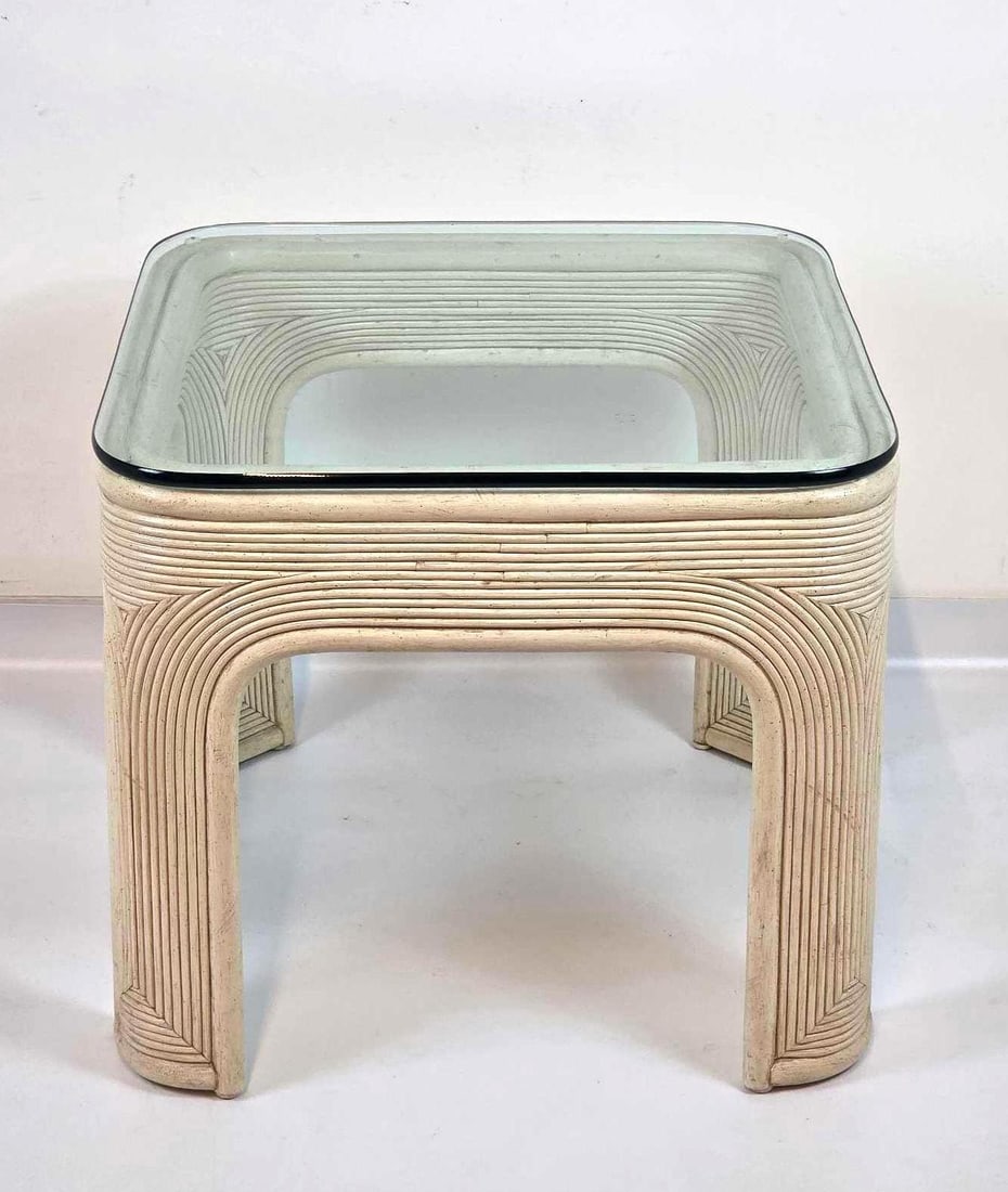 WHITE RATTAN GLASS TOP SIDE TABLE: A vintage, square white pencil reed rattan side table with an inset clear glass top and rounded legs. Approximate Dimensions: 22" H x 25" W x 25" D Artist or Maker: Unknown A New York