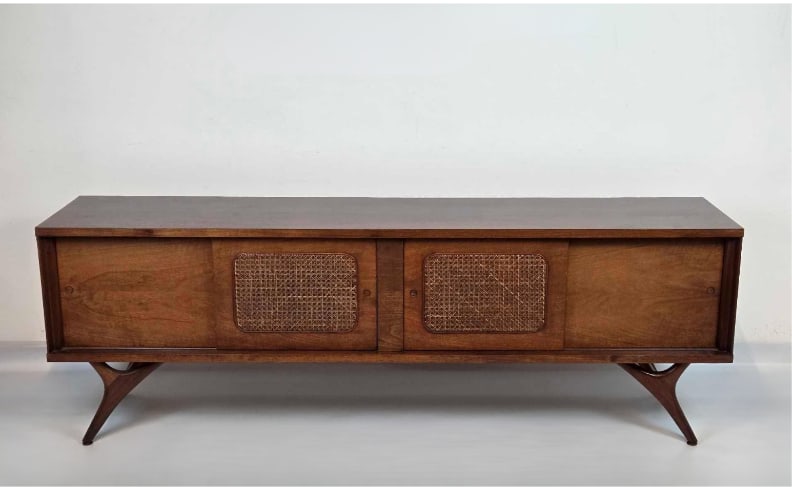 MID CENTURY WALNUT CREDENZA WITH CANE INSET DOORS: Mid-century modern walnut credenza with two central cane-inset sliding doors flanked by solid walnut sliding door panels. Approximate Dimensions: 24"H x 72"W x 16"D Artist or Maker: