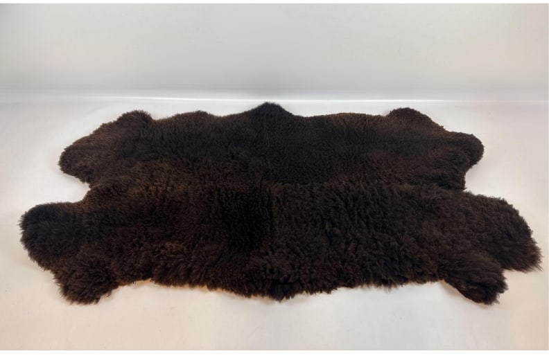 VINTAGE OVERSIZED GENUINE BROWN SHEEPSKIN HIDE AREA RUG: Natural longwool sheepskin pelt throw rug with dense dark brown to black fleece backing in an organic pelt shape Approximate Dimensions: 80”x44” Artis