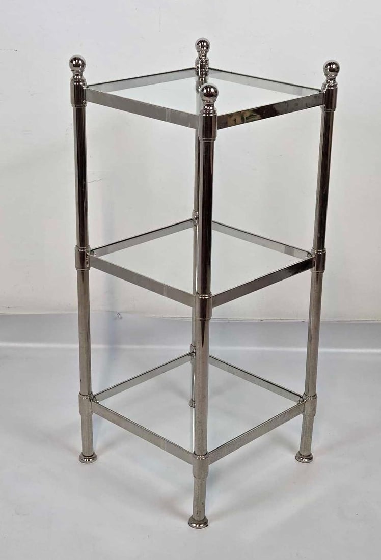 MID CENTURY HOLLYWOOD REGENCY STLE CHROME AND GLASS THREE TIER ETAGERE: Vintage three-tiered tubular chrome display stand with inset glass shelves and ball finials Approximate Dimensions: 31.25" H X 13.25" W X 13.25" D Artist or Maker: Unknown