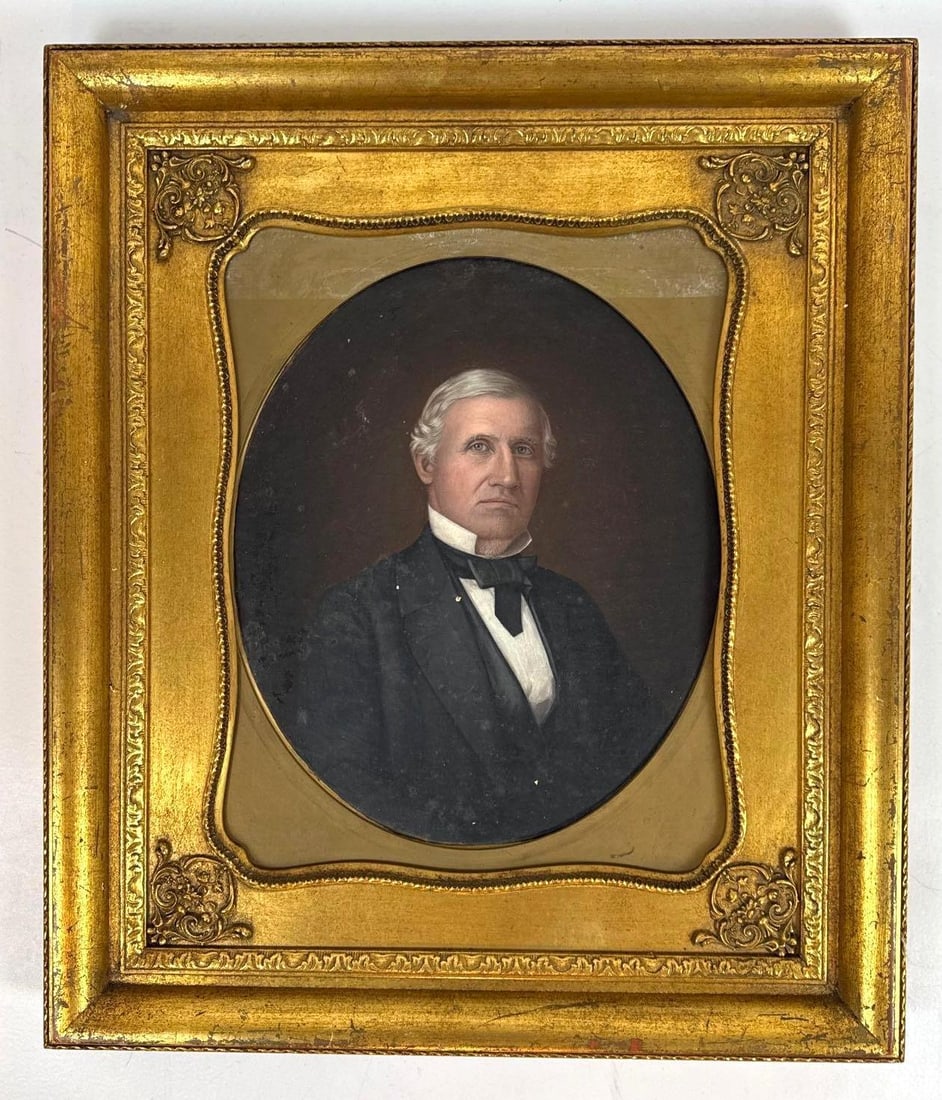 AMERICAN SCHOOL 19TH CENTURY PORTRAIT OF A GENTLEMAN OIL ON CANVAS: Antique 19th-century American School oil on canvas bust portrait of a distinguished silver-haired gentleman in a black coat and bow tie, set within an oval spandrel and housed in an ornate period gilt