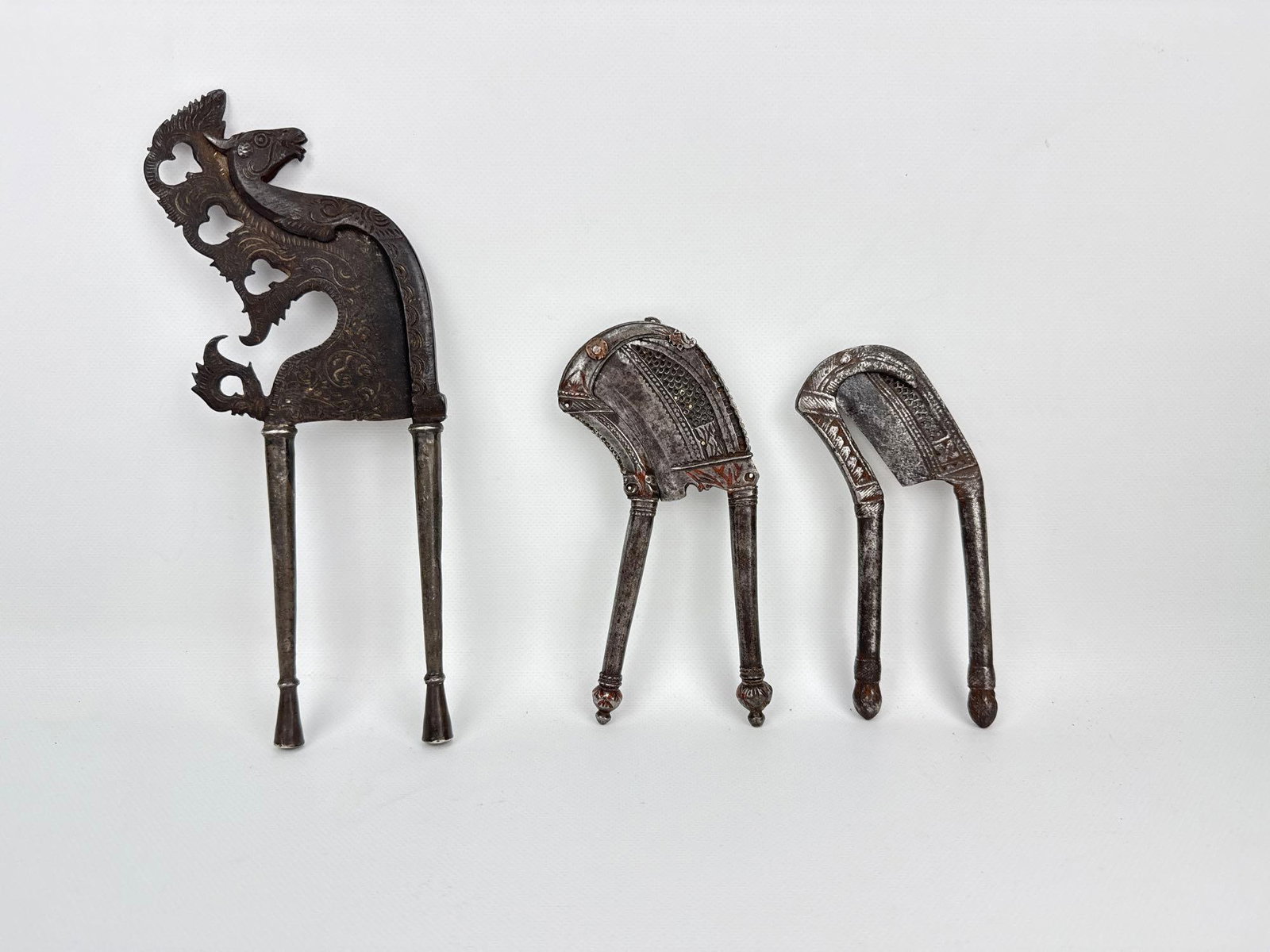 ANTIQUE SOUTHEAST ASIAN BALINESE INDIAN CAKET SAROTA BETEL NUT CUTTERS GROUP: *A collection of three 19th to early 20th-century antique wrought iron and silver or mixed-metal inlaid betel nut cutters (areca nut slicers), including one large Balinese-style zoomorphic "caket&