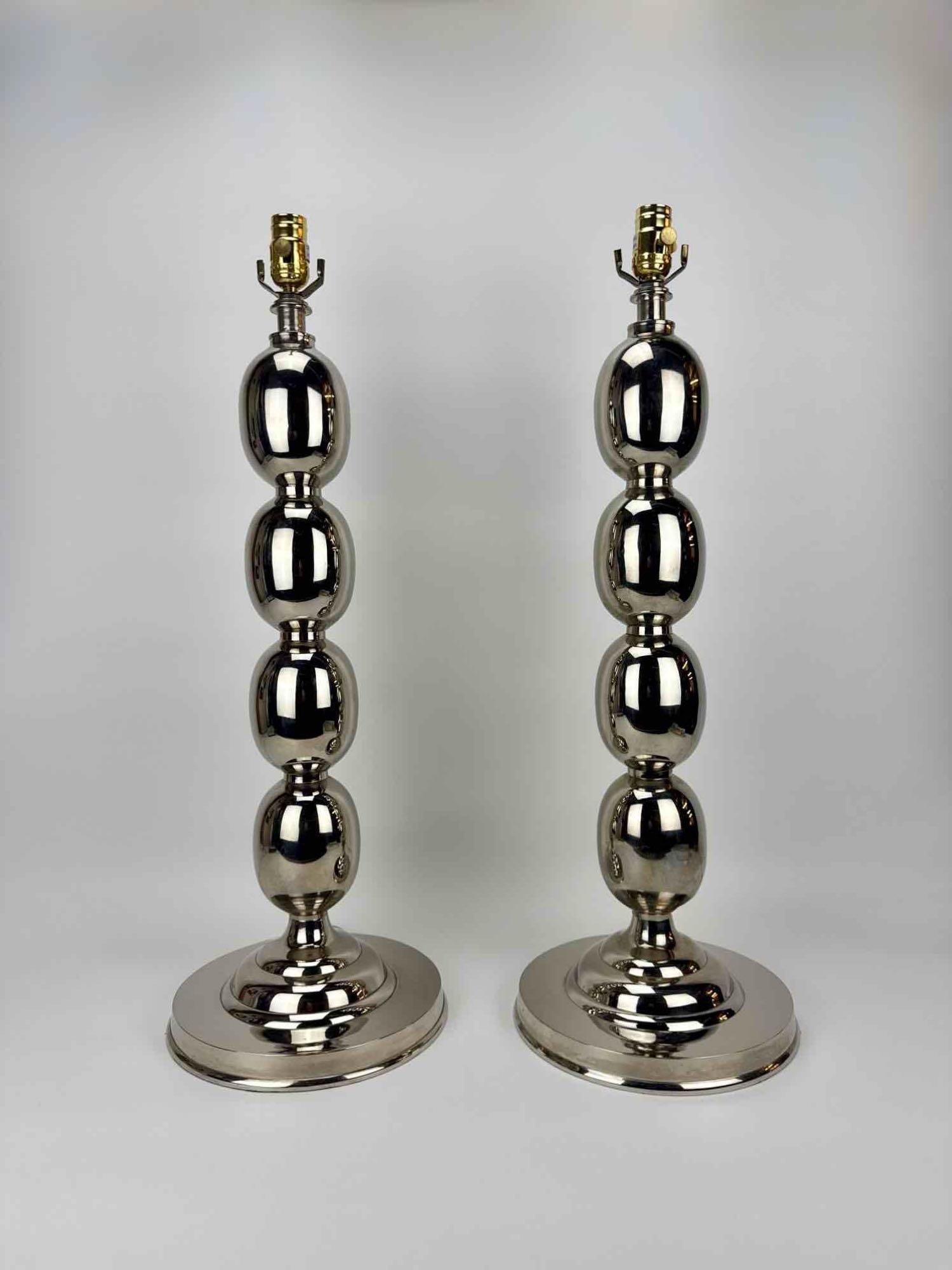 PAIR OF MID CENTURY STYLE STACKED ORB POLISHED NICKEL FINISH TABLE LAMPS: Pair of modern polished nickel stacked ovoid sphere motif table lamp bases on stepped circular pedestals Approximate Dimensions: 28" H X 10.25" Dia.; Harp 36" H Artist or Maker: Unknown