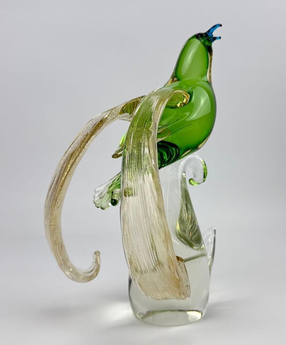 MURANO FORMIA "EMPEROR BIRD OF GERMANY" HAND BLOWN ITALIAN ART GLASS SCULPTURE: Italian Murano art glass bird of paradise sculpture by Formia, featuring a vibrant emerald green blown glass body, blue beak, and cascading gold dust infused tail plumes, perched atop a solid clear gl