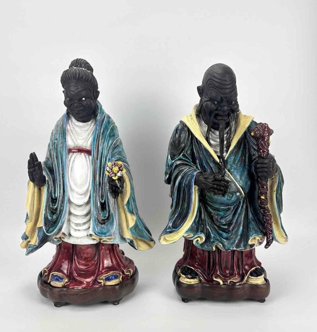 PAIR OF JAPANESE GLAZED CERAMIC FIGURES OF IMMORTALS / DEITIES: Pair of vintage-to-antique Japanese glazed pottery figures representing immortal or deity figures, featuring dark-toned unglazed faces and hands contrasting with vibrant turquoise, yellow, white, and 