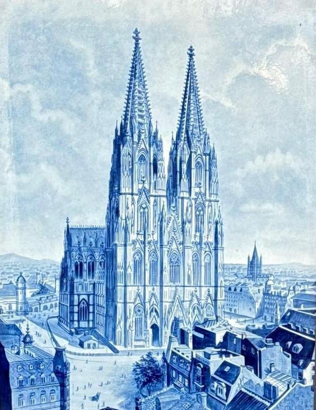 ANTIQUE BLUE AND WHITE CERAMIC PICTORIAL PLAQUE OF COLOGNE CATHEDRAL IN CARVED OAK FRAME: Blue and white glazed ceramic pictorial plaque depicting a view of Cologne Cathedral (Kölner Dom), Germany, set in a carved oak frame with floral marquetry detail. Approximate Dimensions: Plaque: 23&