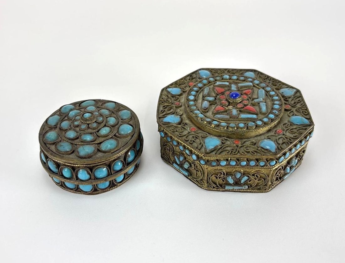 TIBETAN OR NEPALESE BRASS FILIGREE TURQUOISE & CORAL INLAID TRINKET BOXES PAIR: Pair of hand-crafted Himalayan brass filigree trinket boxes comprising a round and an octagonal form, decorated with intricate wirework scrolling and multi-stone inlay. Approximate Dimensions: 1.25