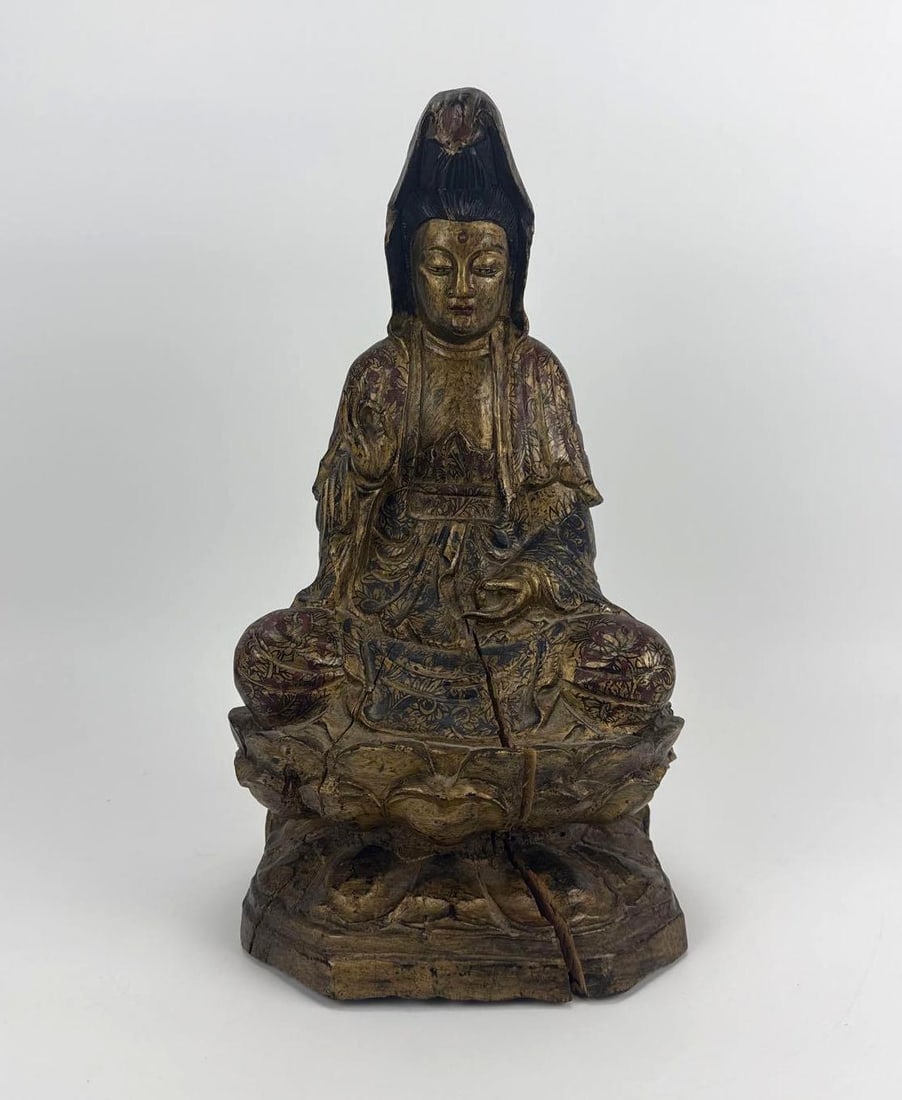 ANTIQUE ASIAN CARVED WOOD GILT & POLYCHROME SEATED GUANYIN FIGURE: Hand-carved wooden sculpture depicting the Bodhisattva Guanyin seated in a serene meditative pose on a lotus pedestal base. Note: Item exhibits prominent vertical age cracks extending through the base
