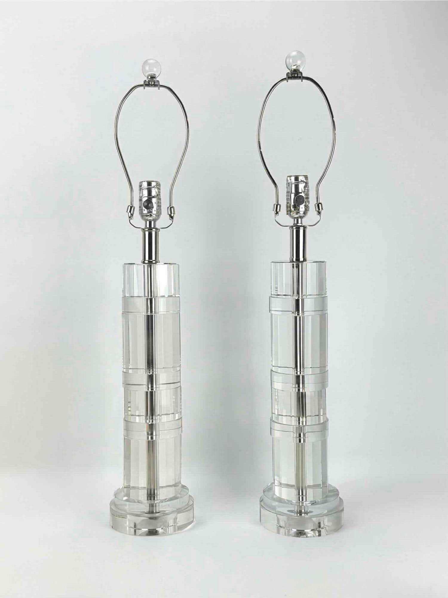 PAIR OF HEAVY CRYSTAL RALPH LAUREN ART DECO LAMPS: Pair of Ralph Lauren crystal table lamps, each with a substantial faceted crystal column body accented by polished chrome bands, on a stepped crystal base. Approximate Dimensions: 21"H x 5.25"